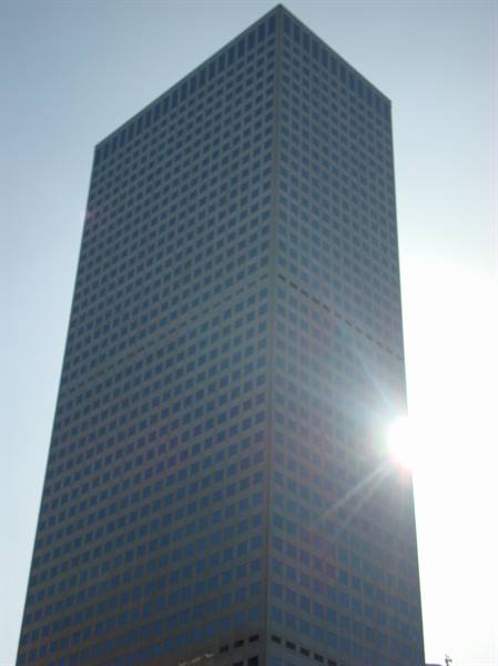 Dark glass skyscraper with sunlight reflecting off its facade