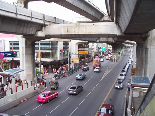 Traffic under concrete BTS viaducts in Bangkok, cars and pink taxis