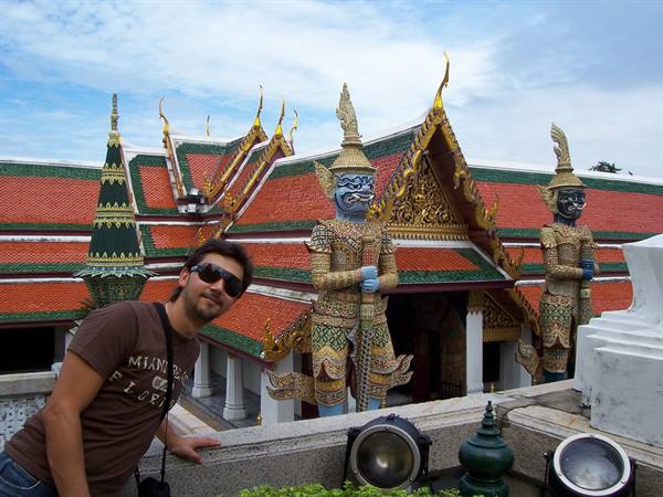 Tourist beside giant yaksha statues at the Grand Palace, Bangkok