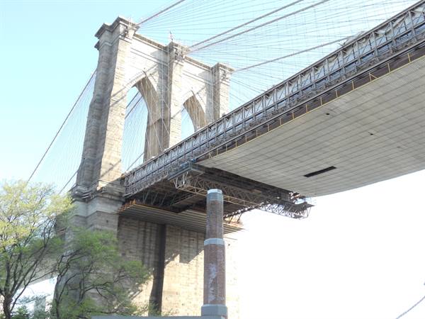 Brooklyn Bridge granite tower with steel cables seen from below