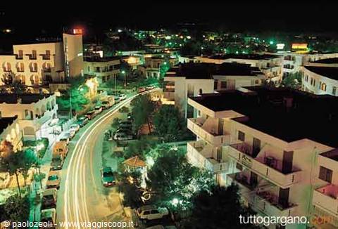 Light trails on a road among white hotels in Gargano at night