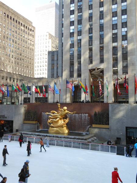 Skaters on the ice rink below the golden Prometheus statue, Rockefeller Center