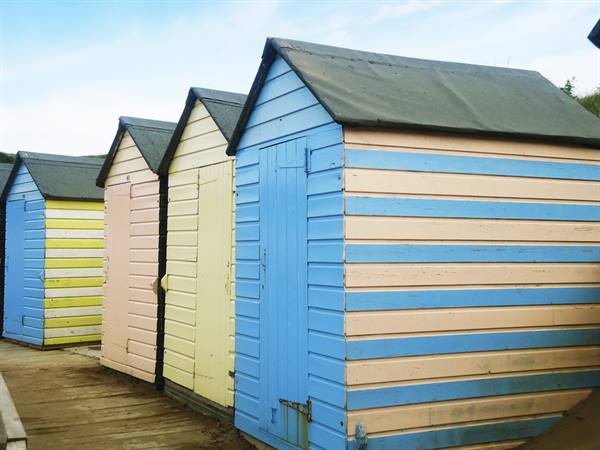 the typical pastel-coloured beach huts of Bude, north Cornwall