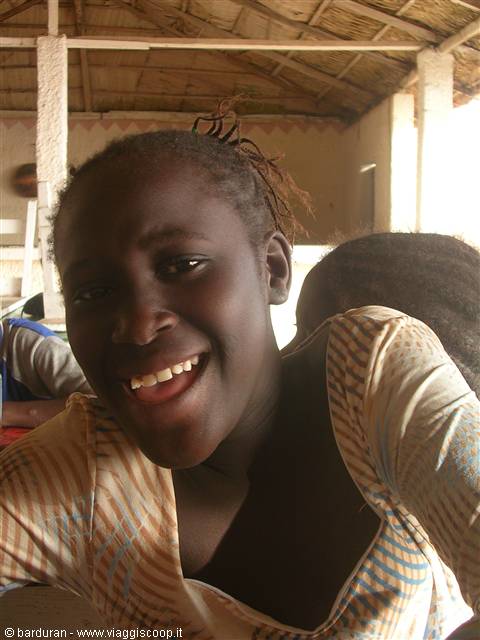 Smiling girl under a thatched roof, natural light