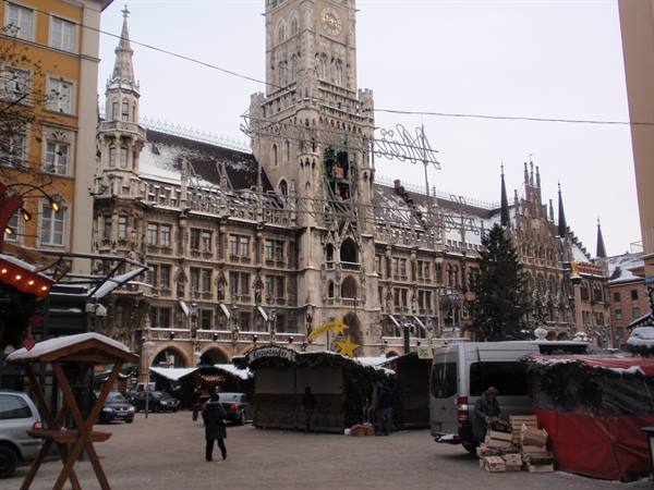 Snowy Christmas market in front of Munich's New Town Hall, wooden stalls and van