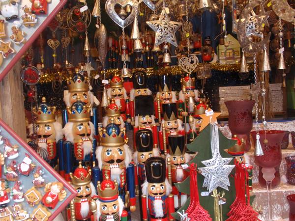 Christmas market stall with painted wooden nutcrackers and hanging golden stars