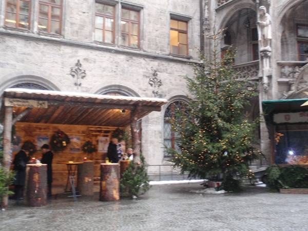 Wooden Christmas market stall and lit tree outside Munich's New Town Hall