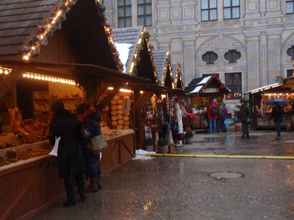 Christmas market in front of Munich Residenz, illuminated wooden stalls with shoppers
