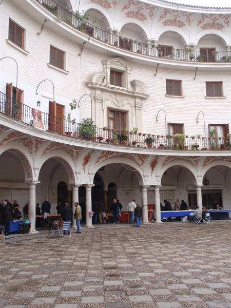 Circular courtyard with white arches and balconies, Plaza del Cabildo, Seville