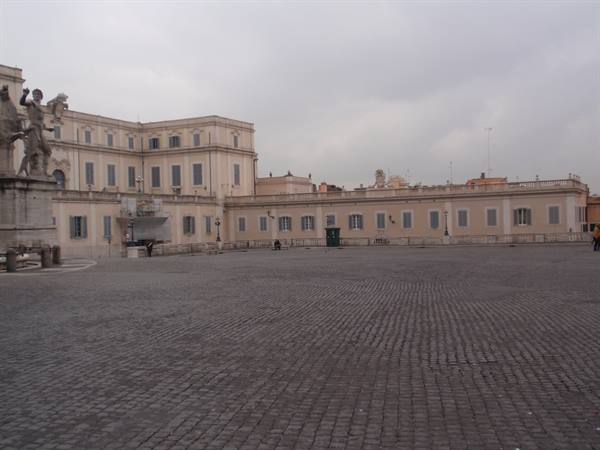 Quirinal Square with palace, statues and cobblestones under a grey sky