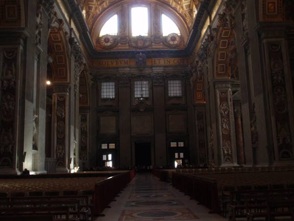 Inside St. Peter's Basilica: dark nave, golden mosaics, light streaming from windows