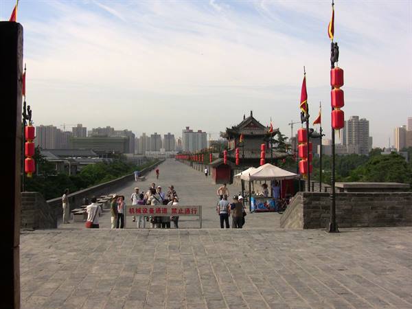 Tourists on the ancient Xi'an city wall with red lanterns and pavilion