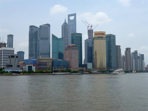 Lujiazui skyscrapers in Shanghai across the Huangpu river, a ferry passes