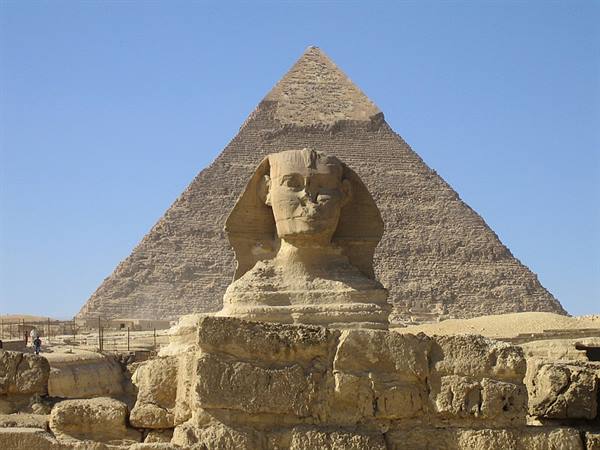 The Great Sphinx of Giza in front of Khufu's pyramid under blue sky