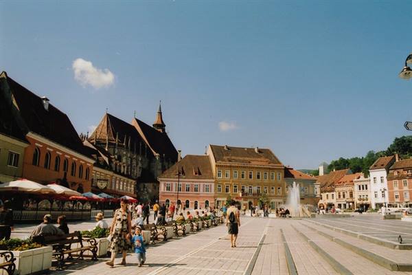 Piața Sfatului in Brașov, pedestrians on cobblestones in front of the Black Church