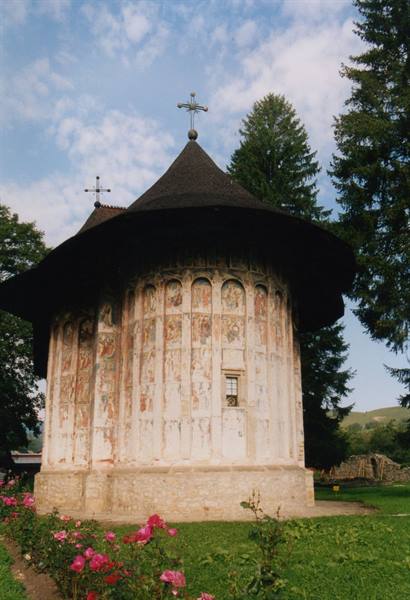Painted church of Humor monastery, frescoed apse among roses and firs