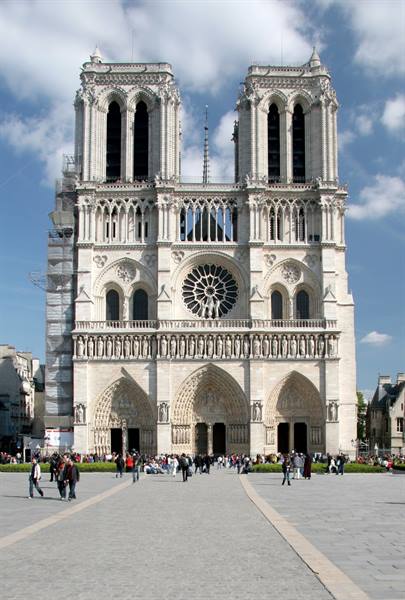 Tourists walk across the square in front of Notre-Dame's Gothic facade