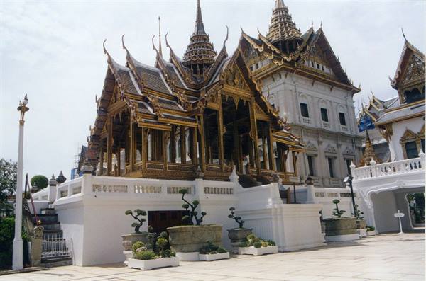 Golden pavilion at Bangkok Grand Palace, thai spires, white marble terrace and planters