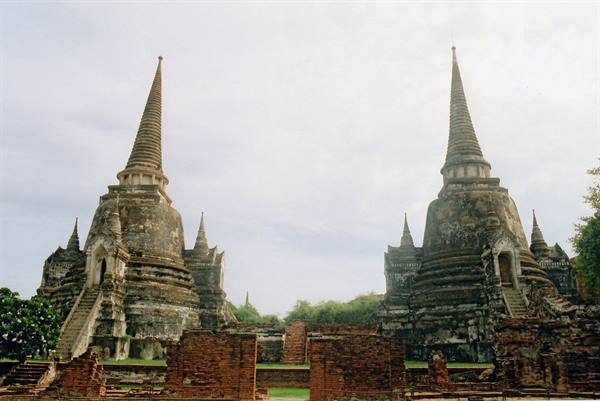 Three moss-covered brick chedis among the ruins of Wat Phra Si Sanphet