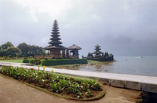 Ulun Danu Bratan temple on the lake waters, flowerbeds in the foreground