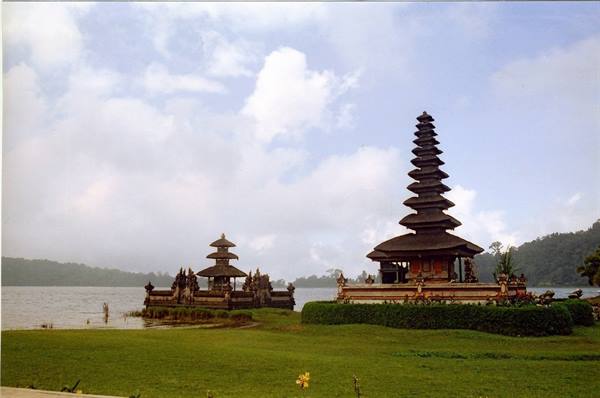 Meru-roofed temple on Lake Bratan in Bali, among clouds and green garden