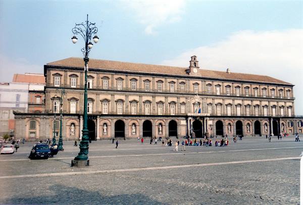 Royal Palace of Naples, stone facade with arches, tourists on the square, daylight