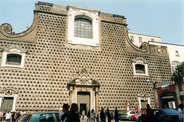 Diamond-stoned facade of Gesù Nuovo church, Naples, with pedestrians and cars