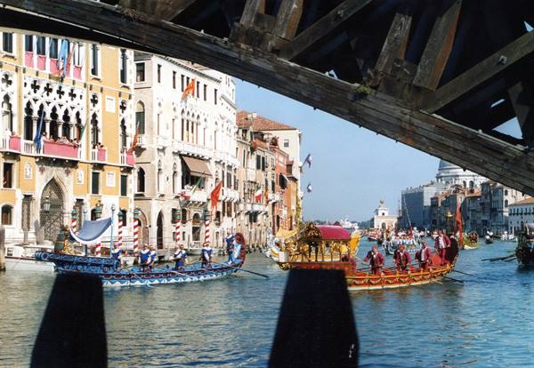 Venice, Grand Canal: historic regatta with ornate boats under wooden bridge