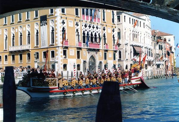 Venice, Grand Canal: golden bissone with costumed rowers passing historic palaces