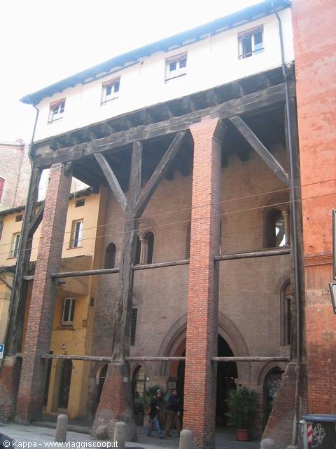 Wooden and brick porticoed building in Bologna, people walking underneath
