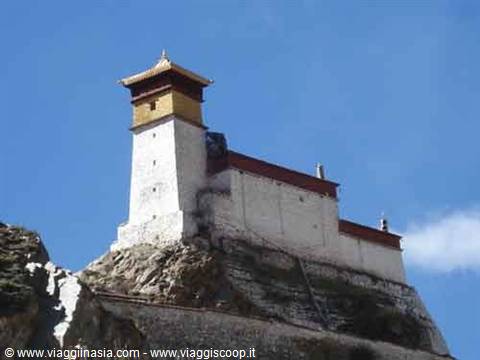 Yumbulagang palace, white fortress atop rocky hill under blue sky