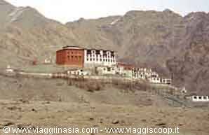 Red and white Buddhist monastery beneath arid mountains