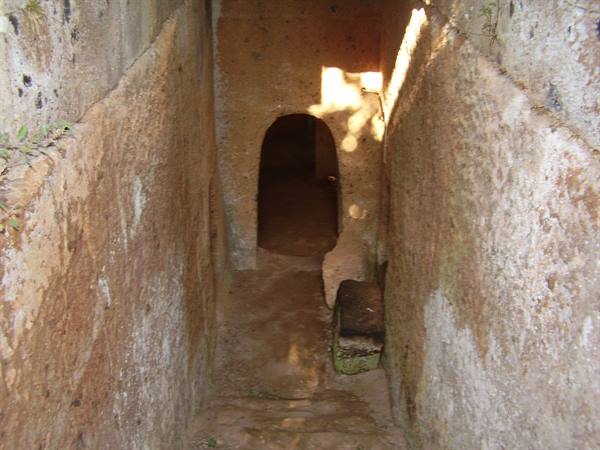Corridor carved in tufa rock with doorway, Etruscan tomb at Cerveteri