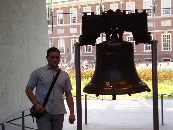 Visitor next to the Liberty Bell displayed in Philadelphia glass pavilion