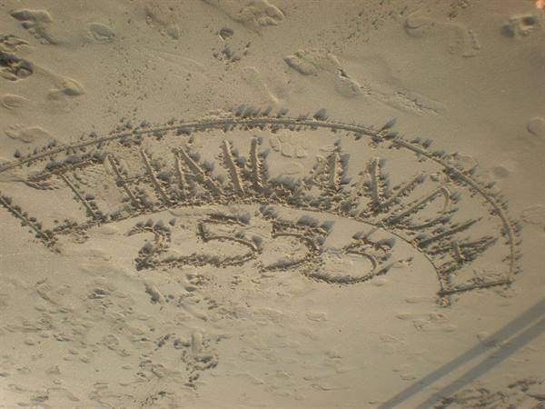 Thailand 2555 written in the wet sand on the beach