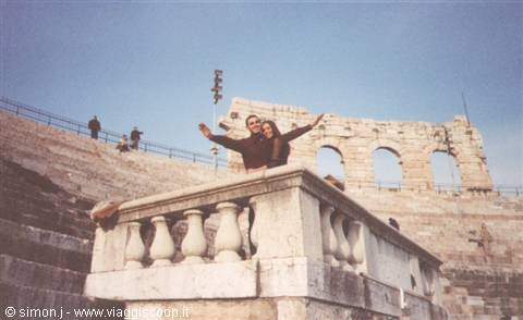 Couple with arms raised on a marble balustrade at Verona Arena