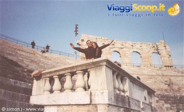 Couple with arms raised on a marble balustrade at Verona Arena