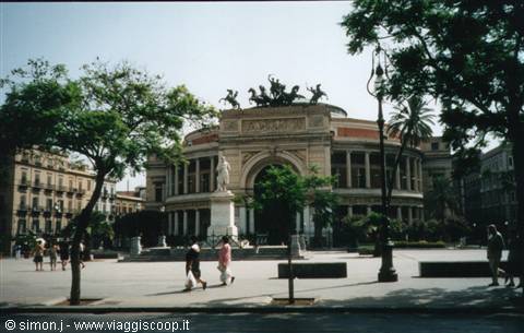 People walk in front of Palermo's Politeama Theatre with bronze chariot statue