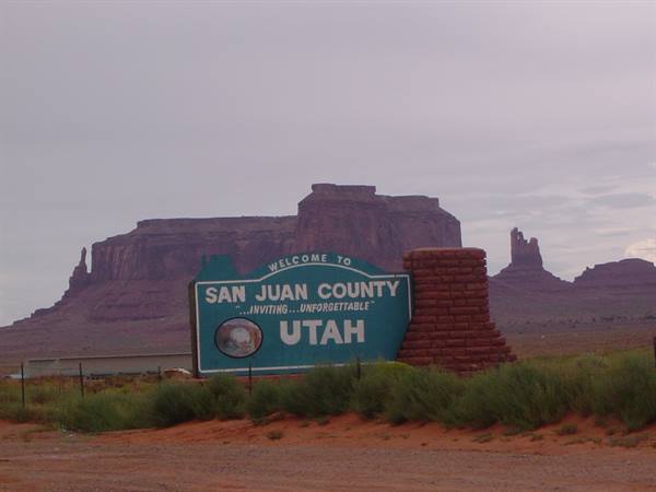Welcome to San Juan County Utah sign in front of Monument Valley red buttes