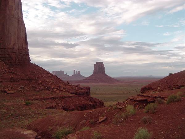 Monument Valley: towering red sandstone buttes under a cloudy sky