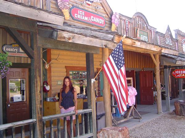 Woman on the wooden porch of an ice cream shop with American flag