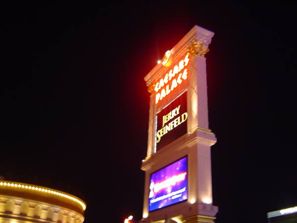 Illuminated Caesars Palace sign at night with bright display screen