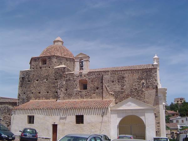 Stone church with brick dome and bell tower, cars parked in front