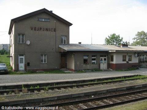 Vejprnice railway station, pale plaster building beside the tracks under overcast sky