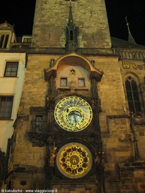 Prague astronomical clock lit at night on the stone facade