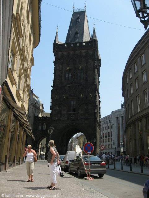 Prague Powder Tower with tourists and parked cars under blue sky