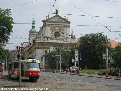 Red and cream tram passing in front of St. Ignatius Church, Prague
