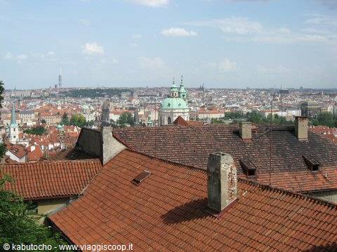 Red-tiled rooftops and green dome in Prague, daylight