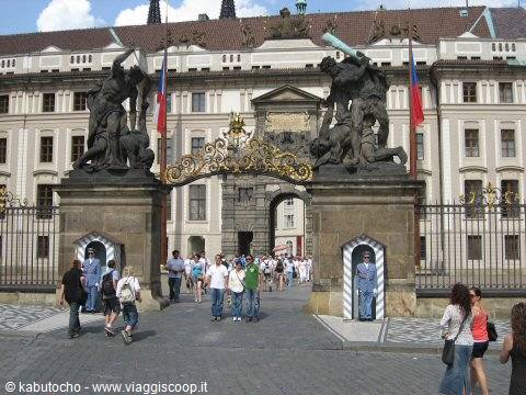 Tourists enter the gate with giant battling titan statues, Prague Castle