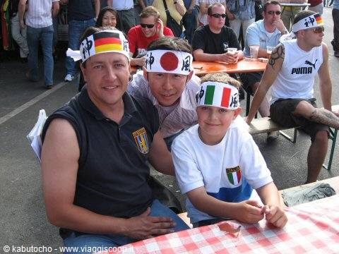 Fans wearing Germany, Japan and Italy headbands at an outdoor table